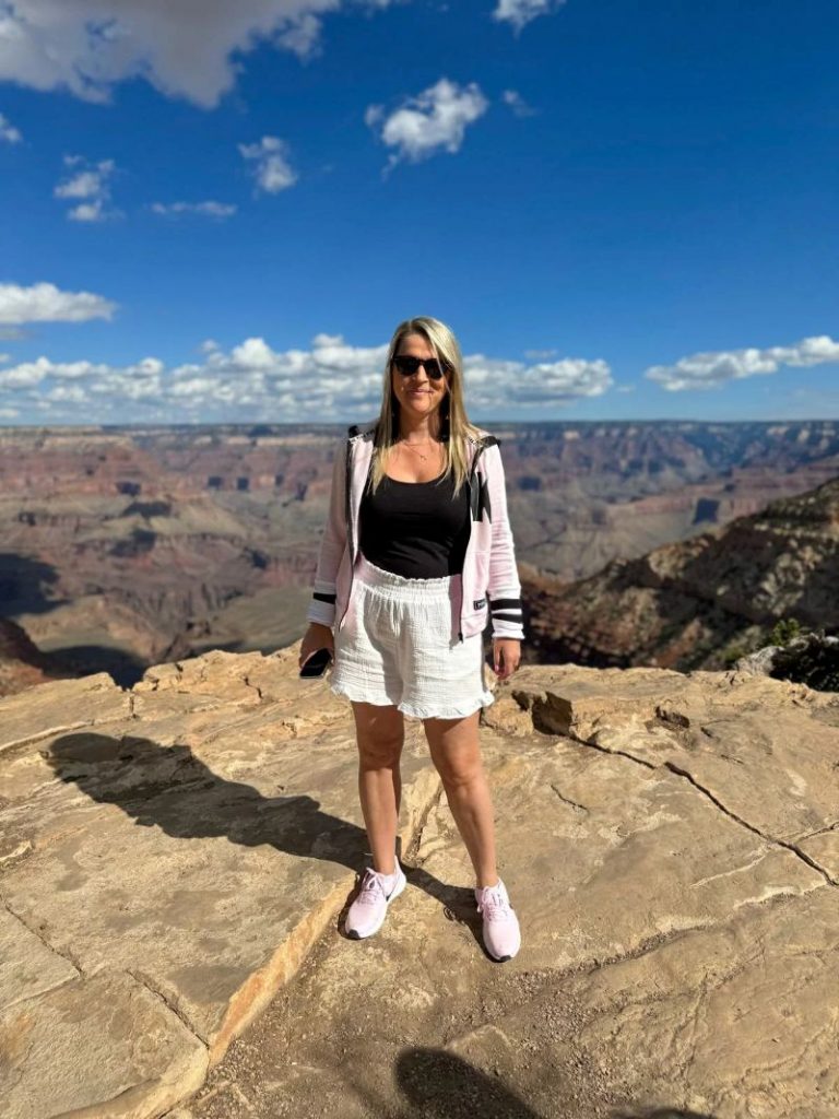 Femme posant sur un rocher et surplombant le grand canyon