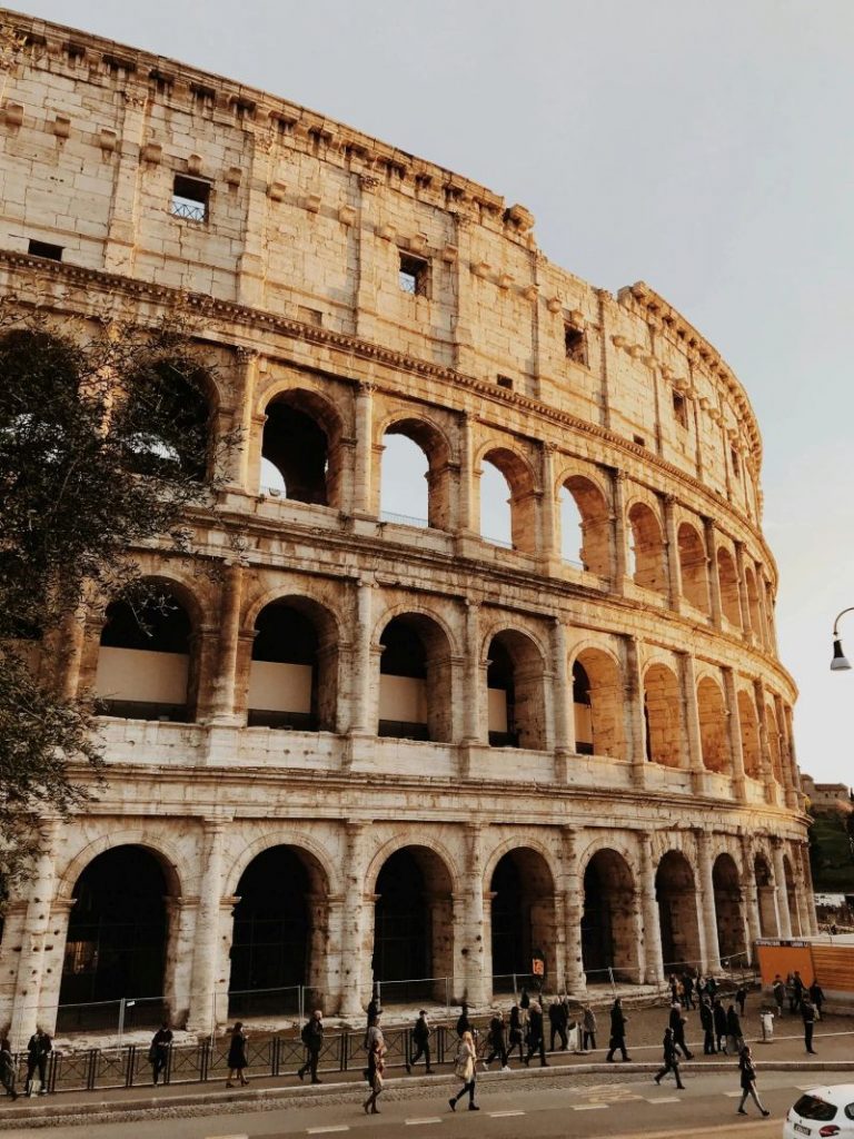 Vue emblématique du Colisée à Rome, en Italie, au coucher du soleil avec des touristes à l'extérieur