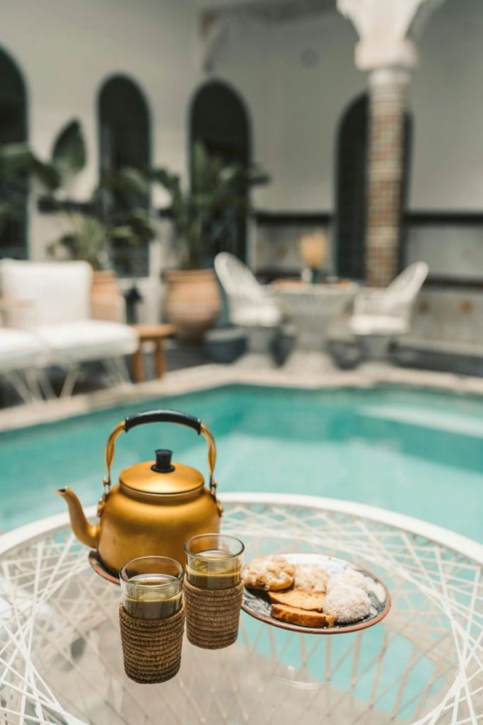 Prendre un thé à la menthe autour d'une piscine d'un riad à Marrakech dans une ambiance traditionnelle